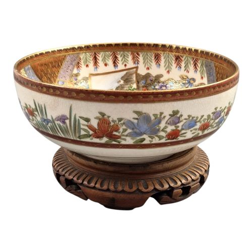 fig 4. An antique Meiji period Japanese Satsuma earthenware bowl featuring hand-painted floral panels and gold detailing, elevated on a carved dark wooden base.