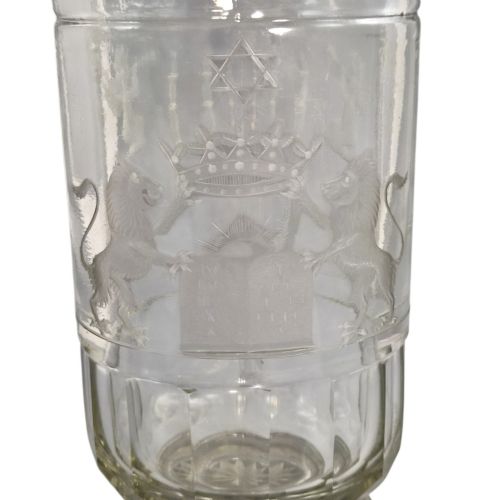 fig 1. A large clear glass beaker featuring detailed wheel-engraved ceremonial iconography, vertical fluted panels near the lower rim, and a faceted base.