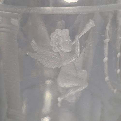 fig 5. A large clear glass beaker featuring detailed wheel-engraved ceremonial iconography, vertical fluted panels near the lower rim, and a faceted base.