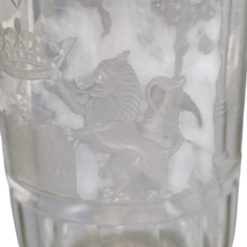 fig 8. A large clear glass beaker featuring detailed wheel-engraved ceremonial iconography, vertical fluted panels near the lower rim, and a faceted base.