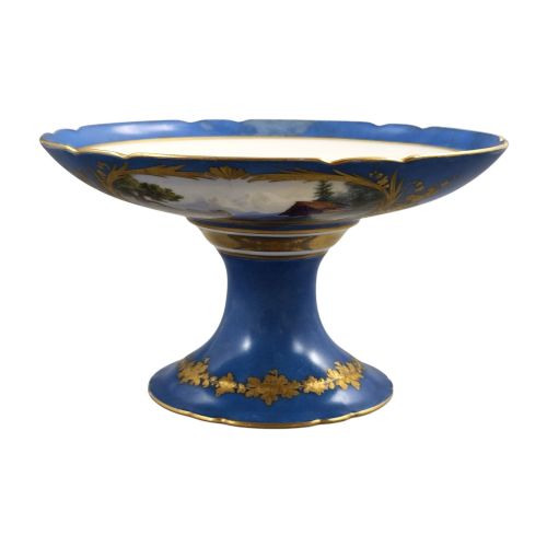 fig 2. A cobalt blue and gilt porcelain tazza elevated on a pedestal base, adorned with a hand-painted winter landscape cartouche.