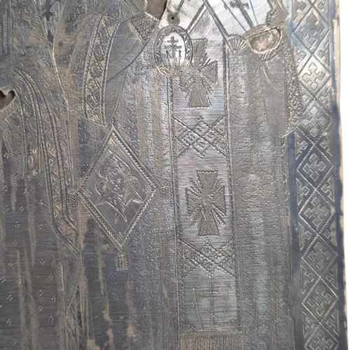 fig 8. A rectangular antique Orthodox silver icon featuring repousse depictions of the Three Holy Hierarchs with detailed halos and Cyrillic script along the bottom edge.