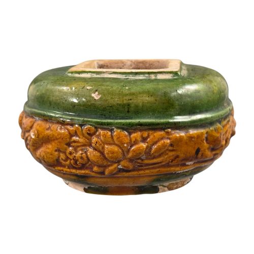 fig 1. A squat antique Chinese ceramic water vessel featuring a green glazed upper shoulder, a square rim, and an amber-glazed moulded floral band around the middle.
