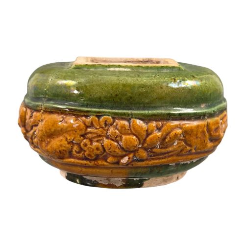 fig 2. A squat antique Chinese ceramic water vessel featuring a green glazed upper shoulder, a square rim, and an amber-glazed moulded floral band around the middle.