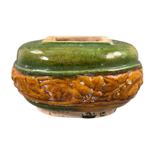 fig 3. A squat antique Chinese ceramic water vessel featuring a green glazed upper shoulder, a square rim, and an amber-glazed moulded floral band around the middle.