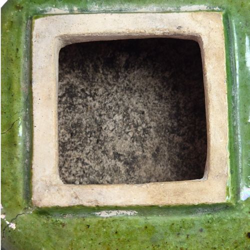 fig 5. A squat antique Chinese ceramic water vessel featuring a green glazed upper shoulder, a square rim, and an amber-glazed moulded floral band around the middle.