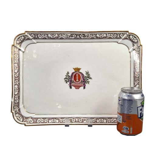 fig 1. An eighteenth-century rectangular white porcelain serving tray featuring shaped corners, delicate gilded scrollwork borders, and a central hand-painted crowned monogram.
