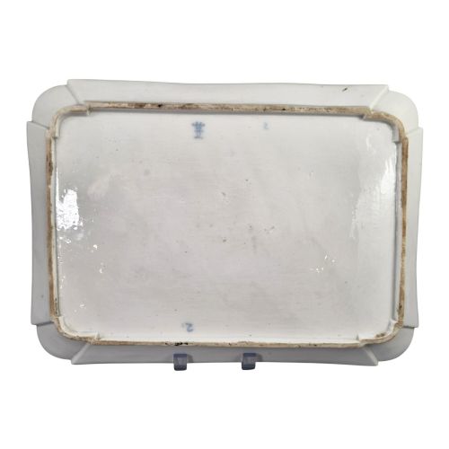 fig 4. An eighteenth-century rectangular white porcelain serving tray featuring shaped corners, delicate gilded scrollwork borders, and a central hand-painted crowned monogram.
