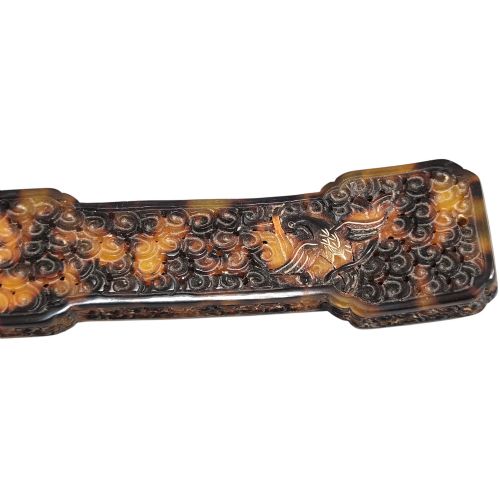 fig 6. A late 19th-century Chinese Qing Dynasty ruyi sceptre carved from translucent mottled amber and dark brown tortoiseshell with intricate relief carving along the handle and head.