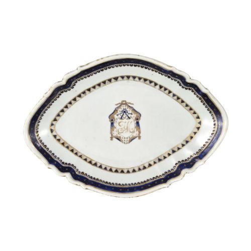 fig 6. A five-piece late 18th-century Chinese export porcelain tea service featuring two cream jugs, two saucers, and a footed dish decorated with cobalt blue borders, gilt detailing, and central monograms.