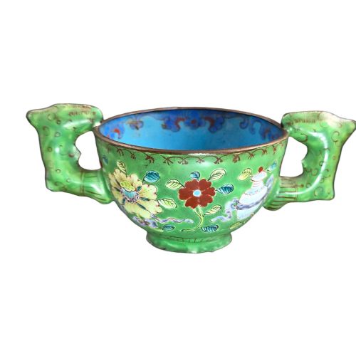 fig 1. An eighteenth-century Chinese Canton enamel wine cup with green dragon-shaped handles resting on a matching round saucer, decorated with floral motifs and symbols.