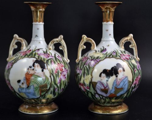 fig 2. A pair of Japanese Yokohama porcelain vases decorated with hand-painted figures, floral irises, twin gilt handles, and gilded neck details.