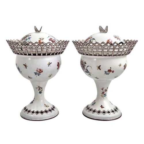 fig 1. A pair of off-white 19th-century French tole peinte chestnut urns featuring hand-painted botanical motifs, pierced lattice galleries, and shell-form finials on the lids.