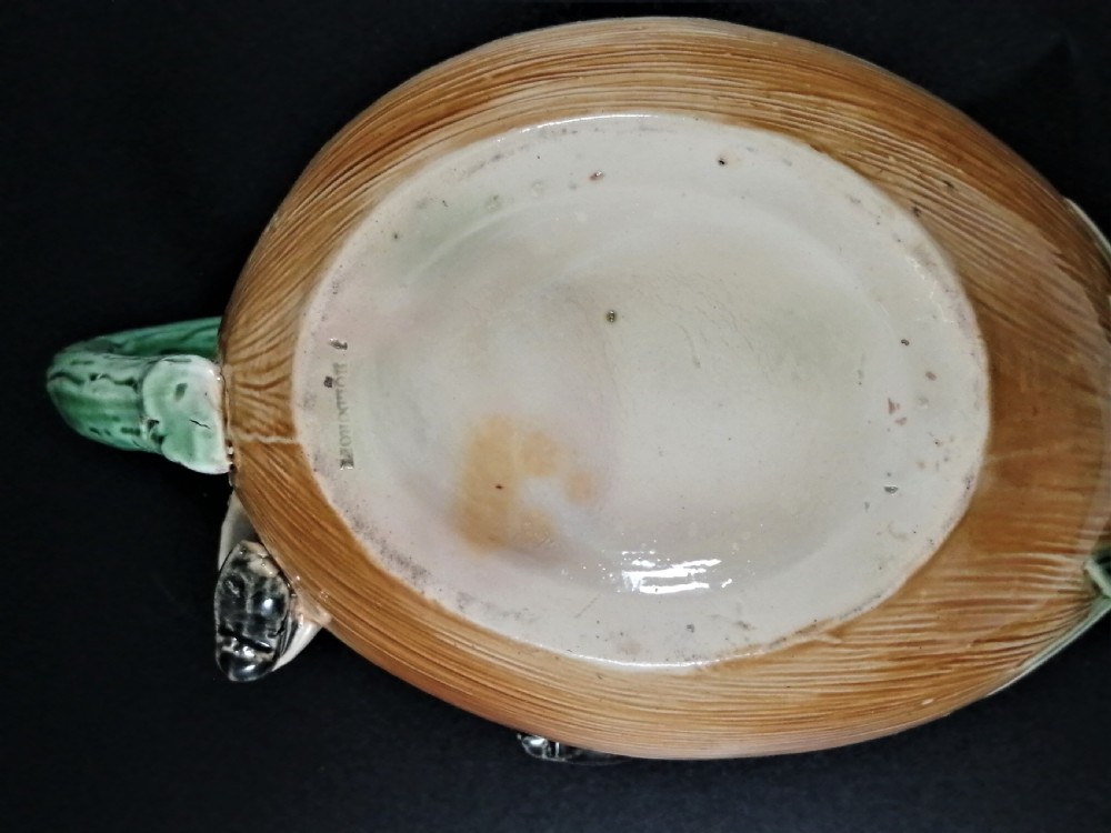 A Victorian earthenware majolica teapot shaped as a melon with a figure of a boy in a blue jacket seated on top forming the lid. View XIV