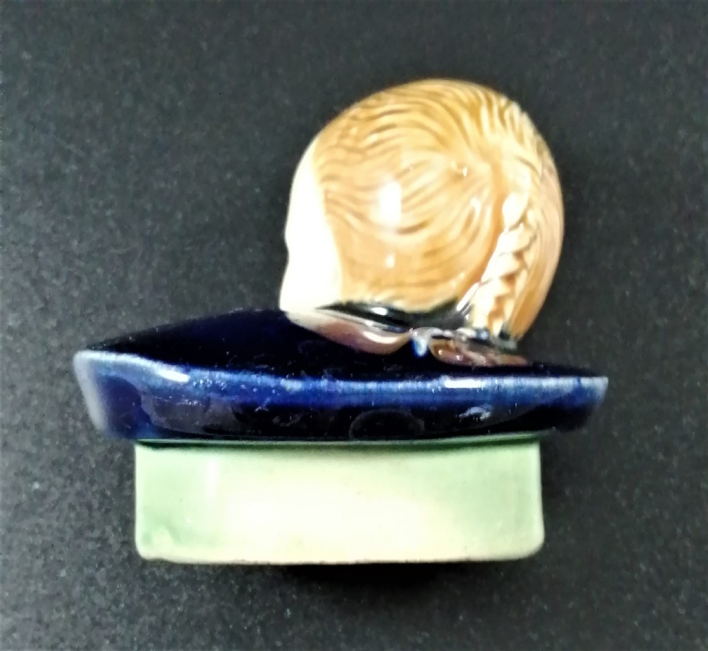 A Victorian earthenware majolica teapot shaped as a melon with a figure of a boy in a blue jacket seated on top forming the lid. View XVII