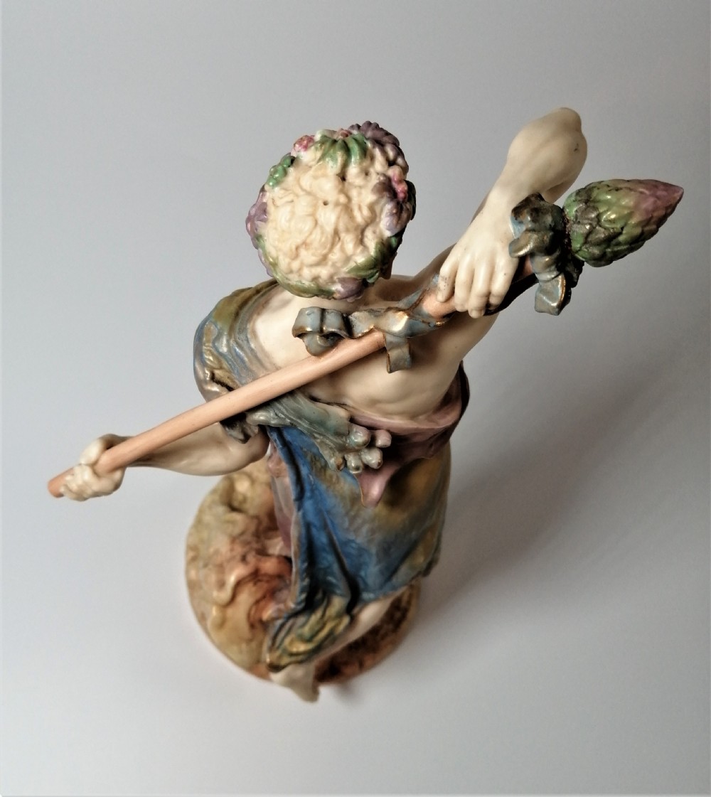 A Victorian Royal Worcester porcelain figurine depicting a male satyr draped in blue and gold robes, holding a staff over his shoulder. View XV