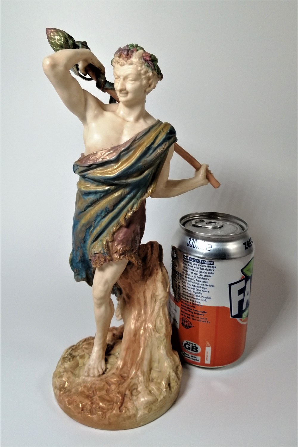 A Victorian Royal Worcester porcelain figurine depicting a male satyr draped in blue and gold robes, holding a staff over his shoulder. View XIX