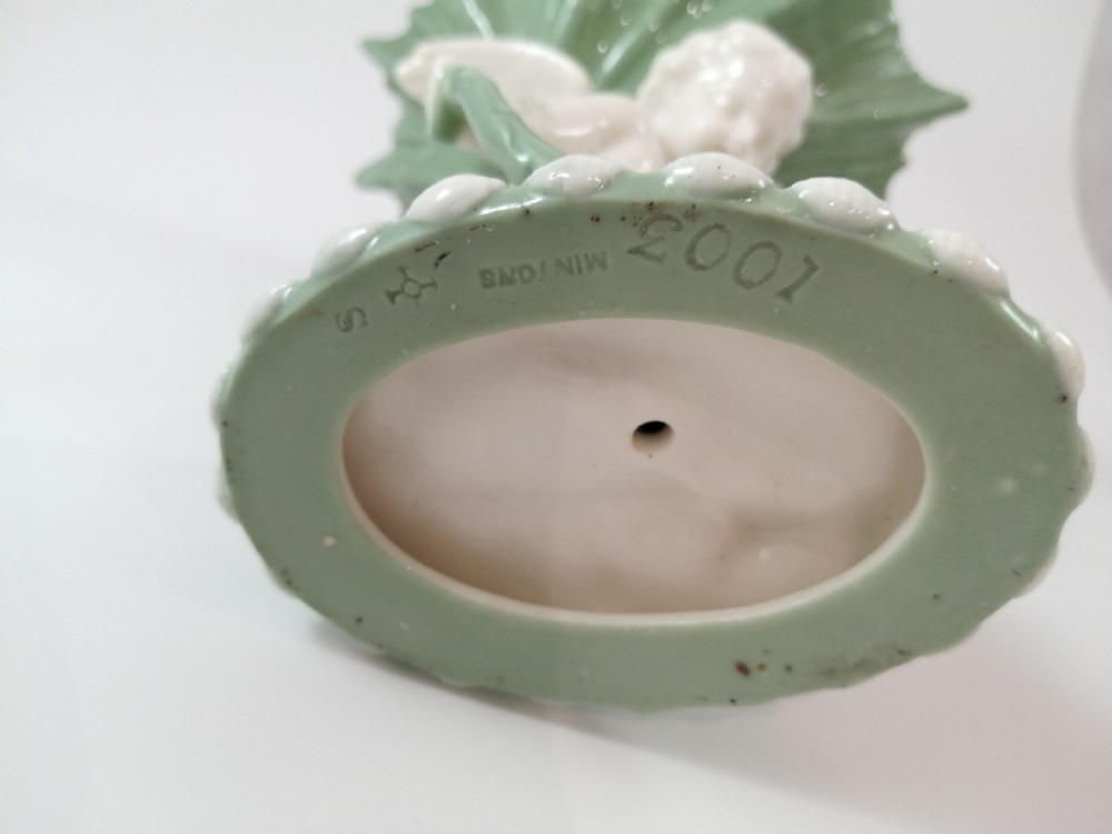 A pair of Victorian ceramic compotes featuring unglazed white cherub figures holding green leaf-shaped bowls aloft while seated on green glazed dolphin bases. View X