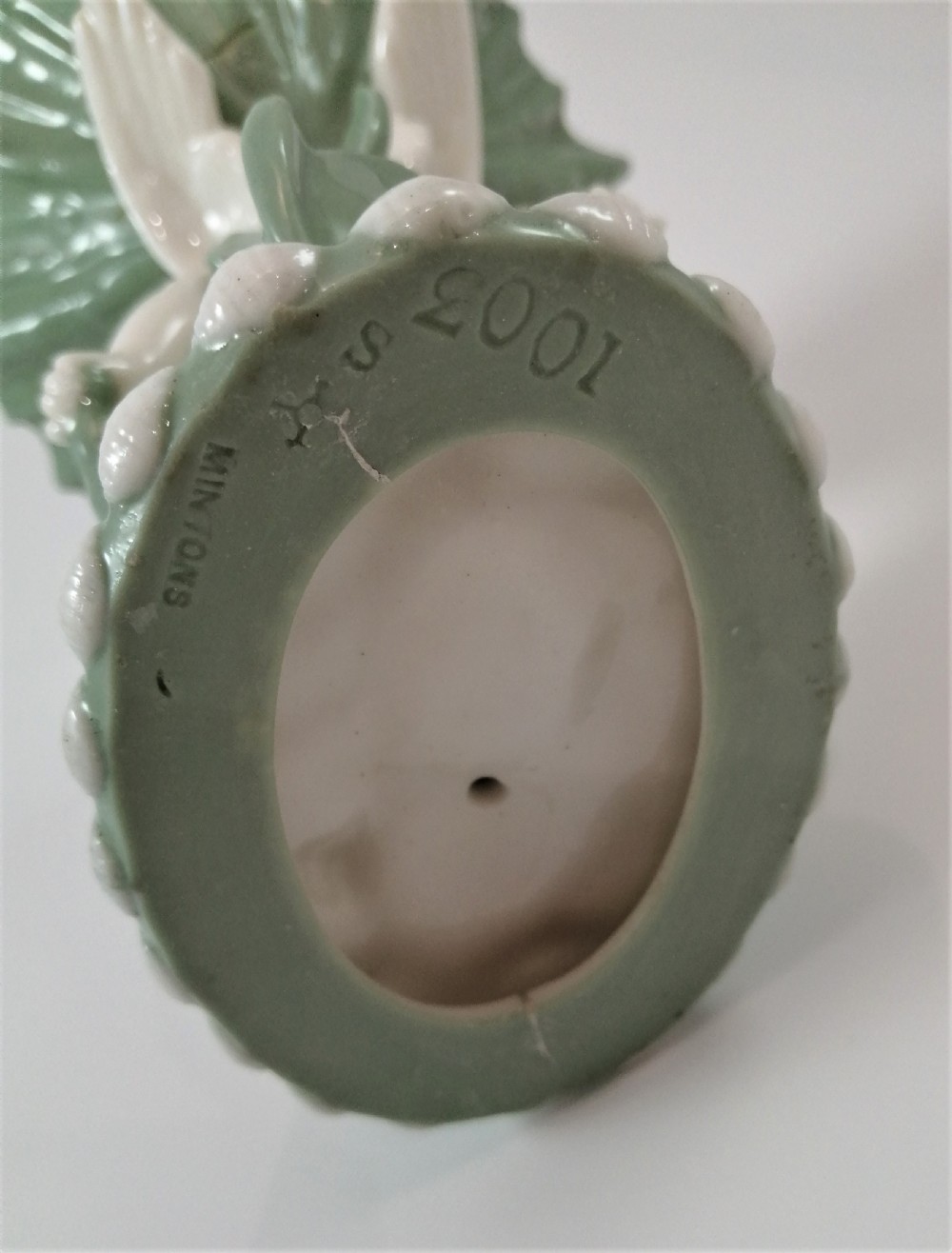 A pair of Victorian ceramic compotes featuring unglazed white cherub figures holding green leaf-shaped bowls aloft while seated on green glazed dolphin bases. View XVIII