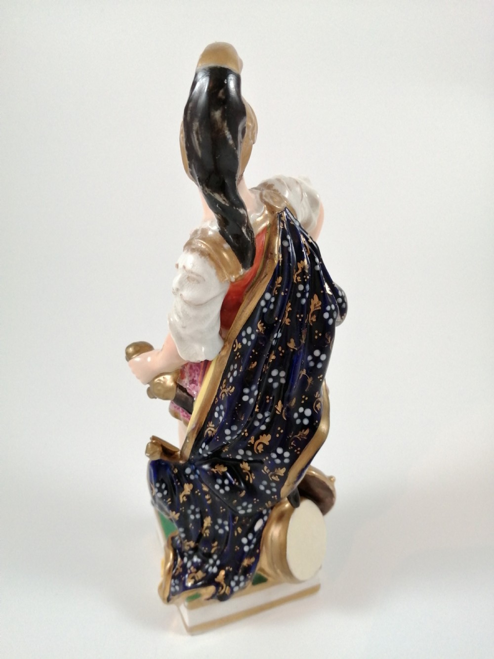 An antique hand-painted porcelain figure depicting the Roman god Mars in gilded armour, a pink tunic, and a golden helmet, standing on a green base. View IV