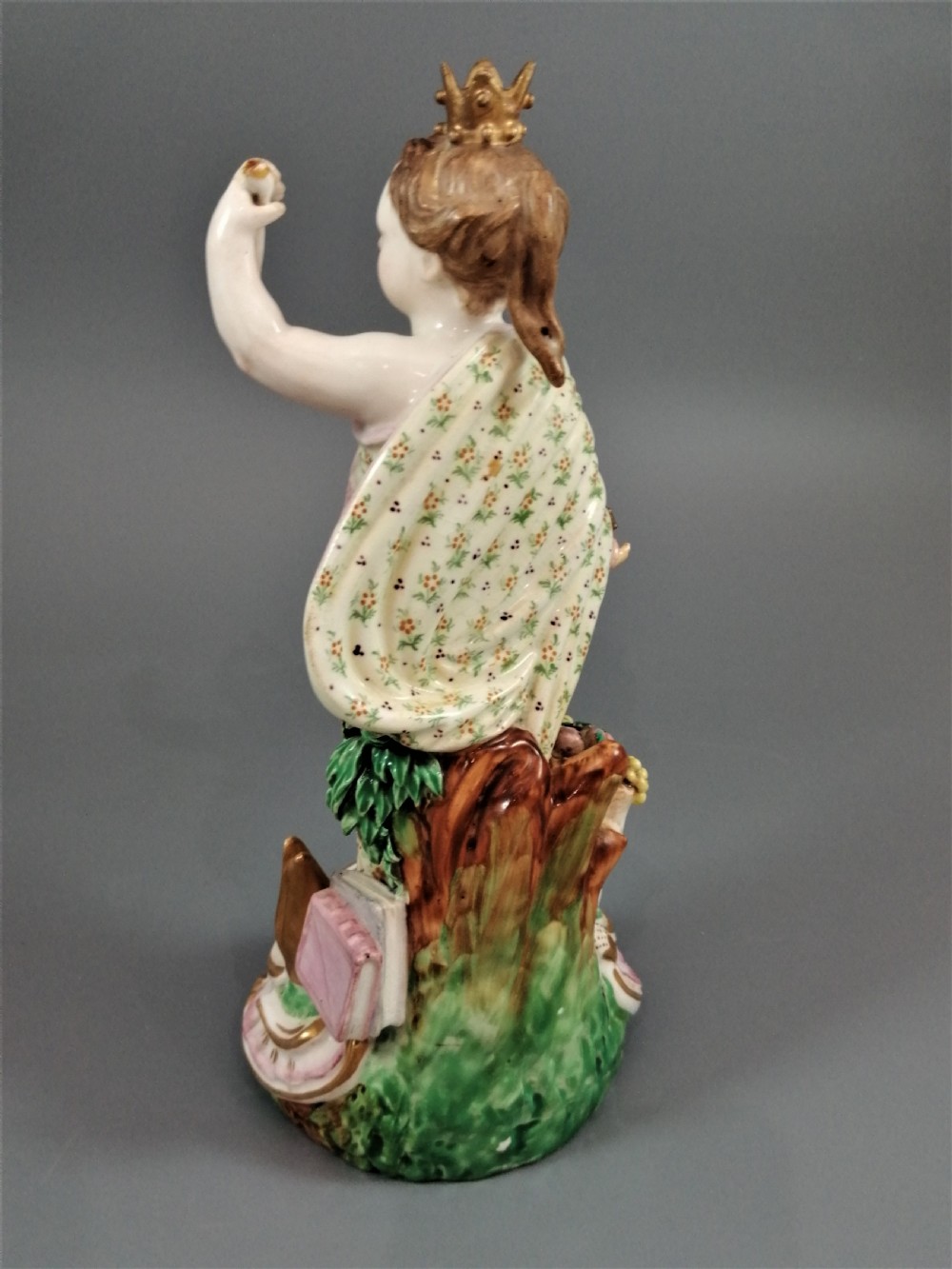 An 18th-century Derby soft-paste porcelain statuette representing Europe, featuring a crowned figure in patterned drapery standing on a gilded scrollwork base. View VI