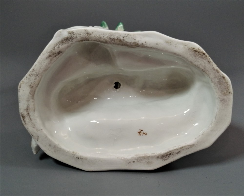 An 18th-century Chelsea soft-paste porcelain figurine depicting an allegorical female figure of Asia seated beside a camel beneath a palm tree. View XIV