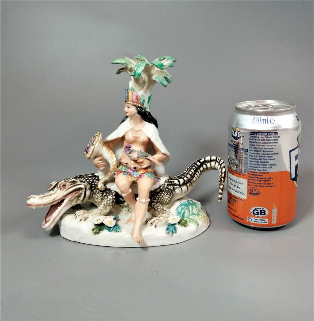An 18th-century Chelsea polychrome porcelain statuette depicting an allegorical female figure seated on an alligator beside a palm tree. View XII