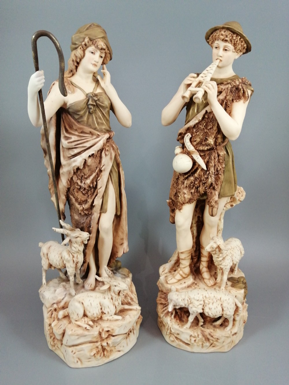 a pair of shepherd and shepherdess statuettes made of royal dux porcelain