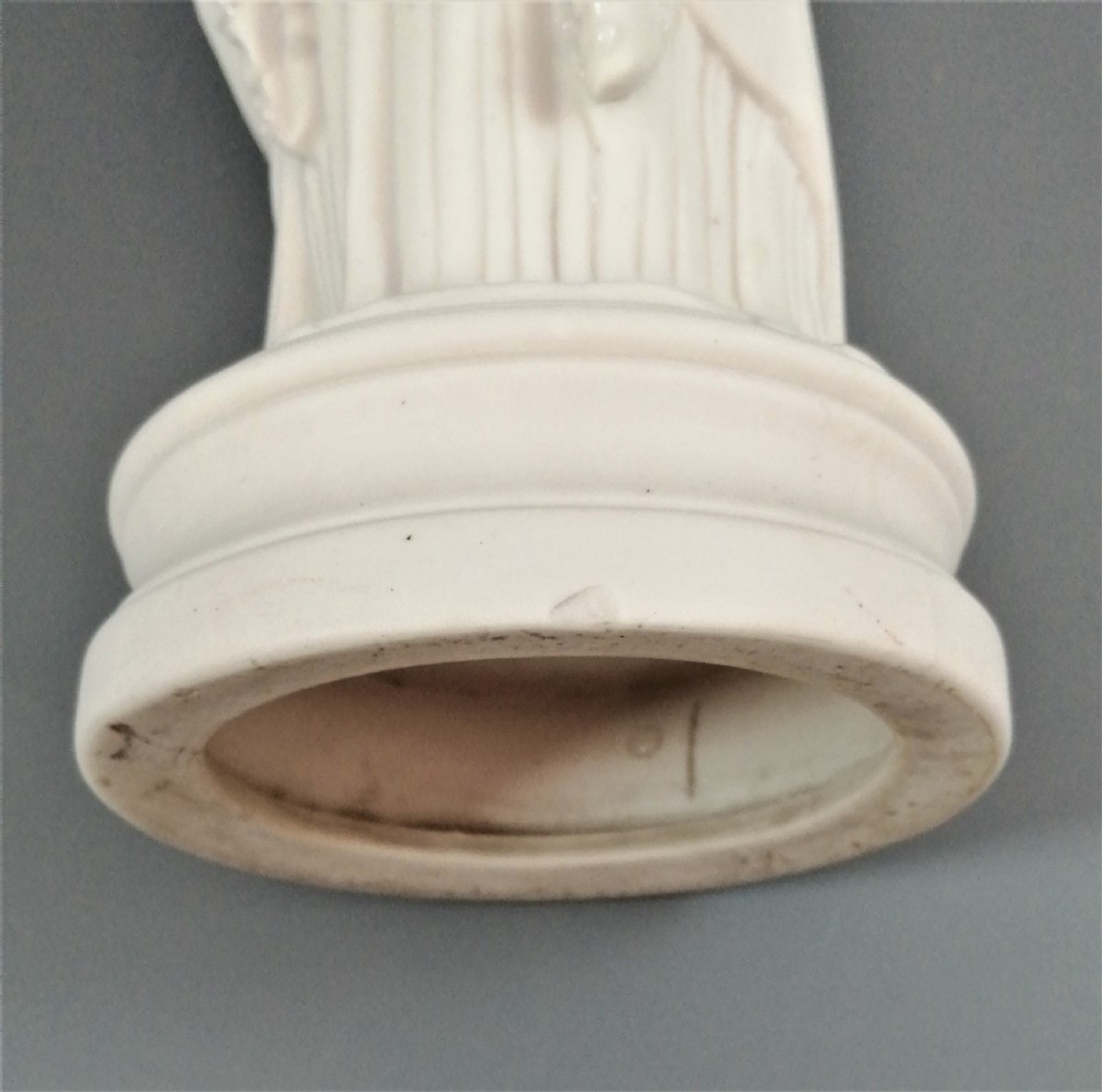 A nineteenth-century Victorian Parian ware figurine depicting a classically draped maiden holding a fruit basket on her shoulder. View VIII