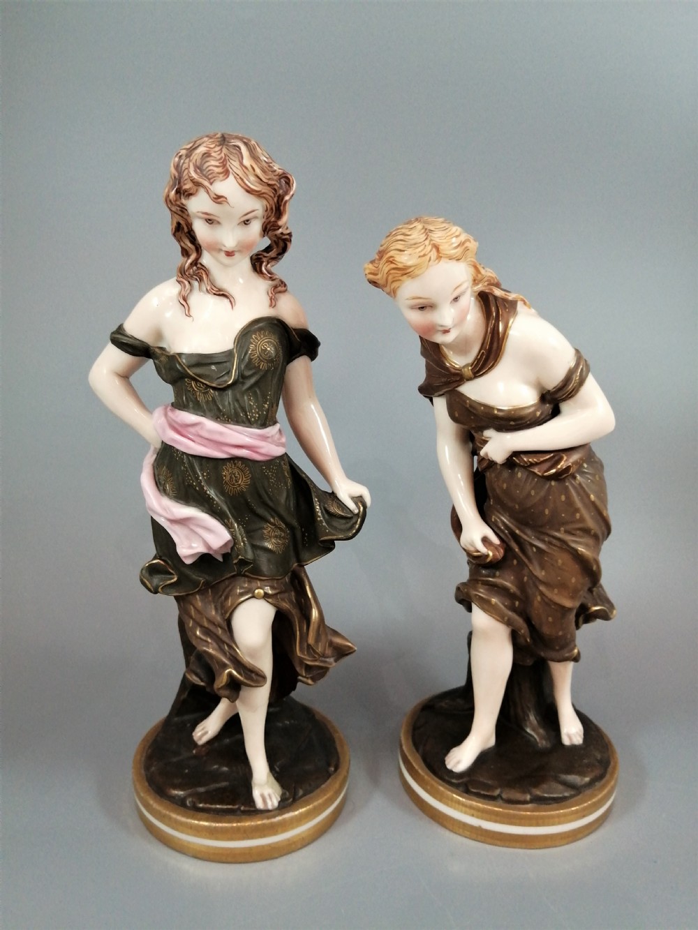 A pair of nineteenth-century Royal Worcester porcelain figurines depicting draped female figures with windblown hair and garments.