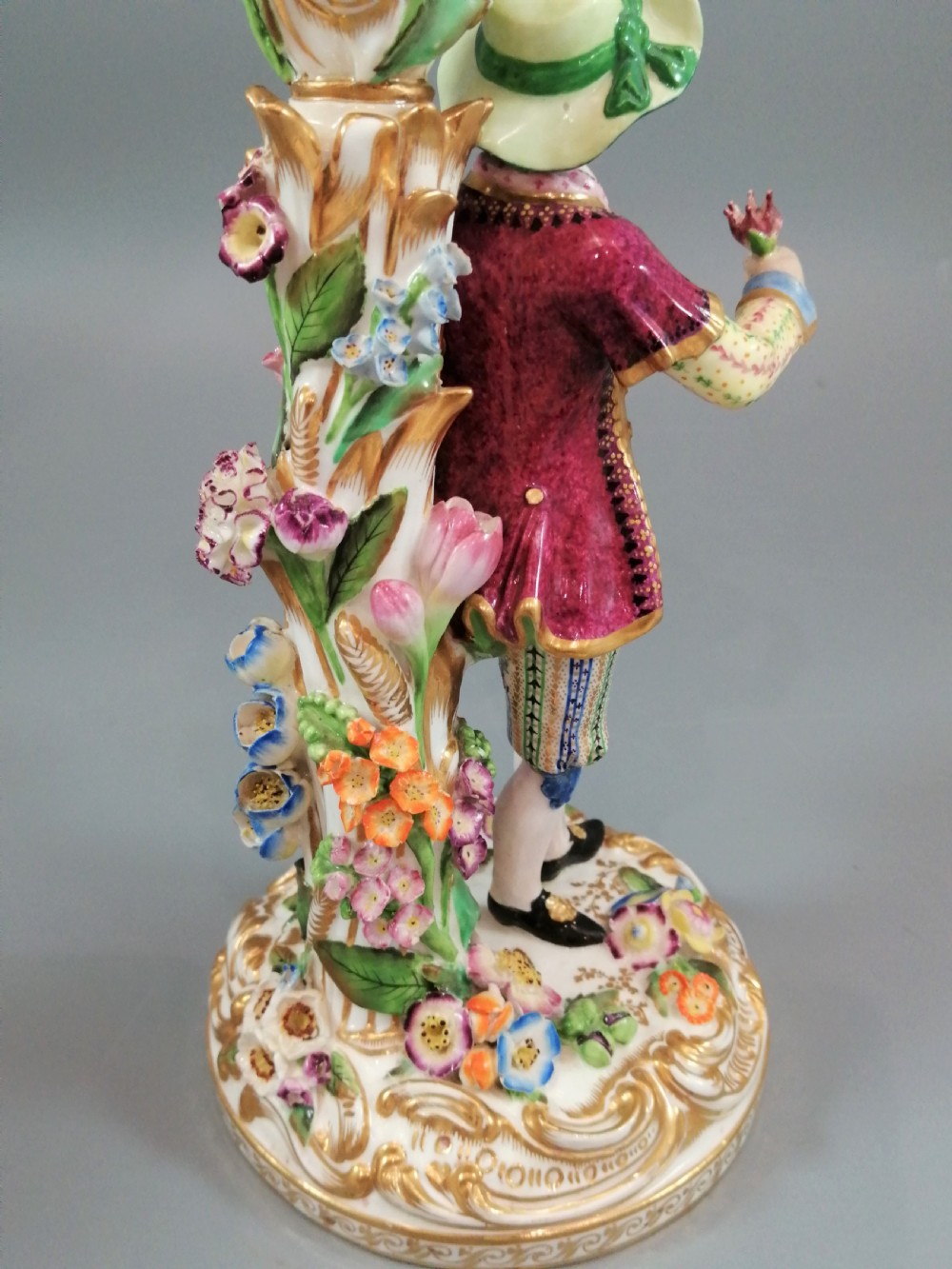 A pair of hand-painted Minton porcelain figural candlesticks featuring a male and female figure in colourful traditional dress with floral motifs and gilded scroll bases. View XII