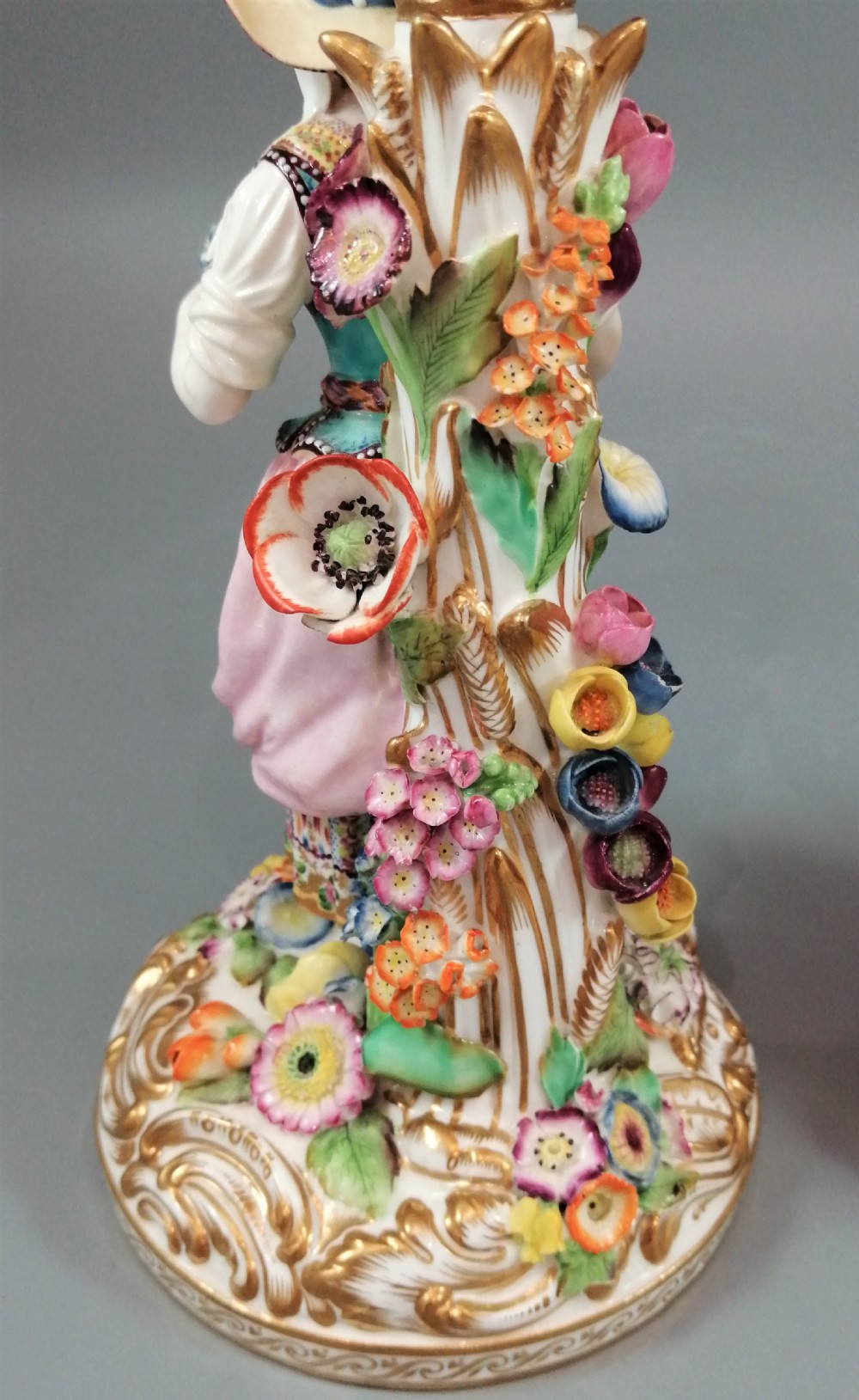 A pair of hand-painted Minton porcelain figural candlesticks featuring a male and female figure in colourful traditional dress with floral motifs and gilded scroll bases. View XIII