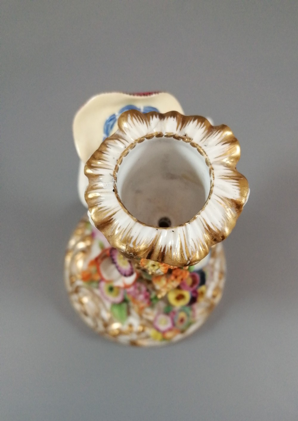 A pair of hand-painted Minton porcelain figural candlesticks featuring a male and female figure in colourful traditional dress with floral motifs and gilded scroll bases. View XX