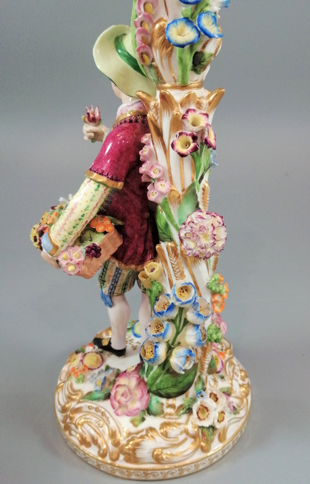 A pair of hand-painted Minton porcelain figural candlesticks featuring a male and female figure in colourful traditional dress with floral motifs and gilded scroll bases. View XXI
