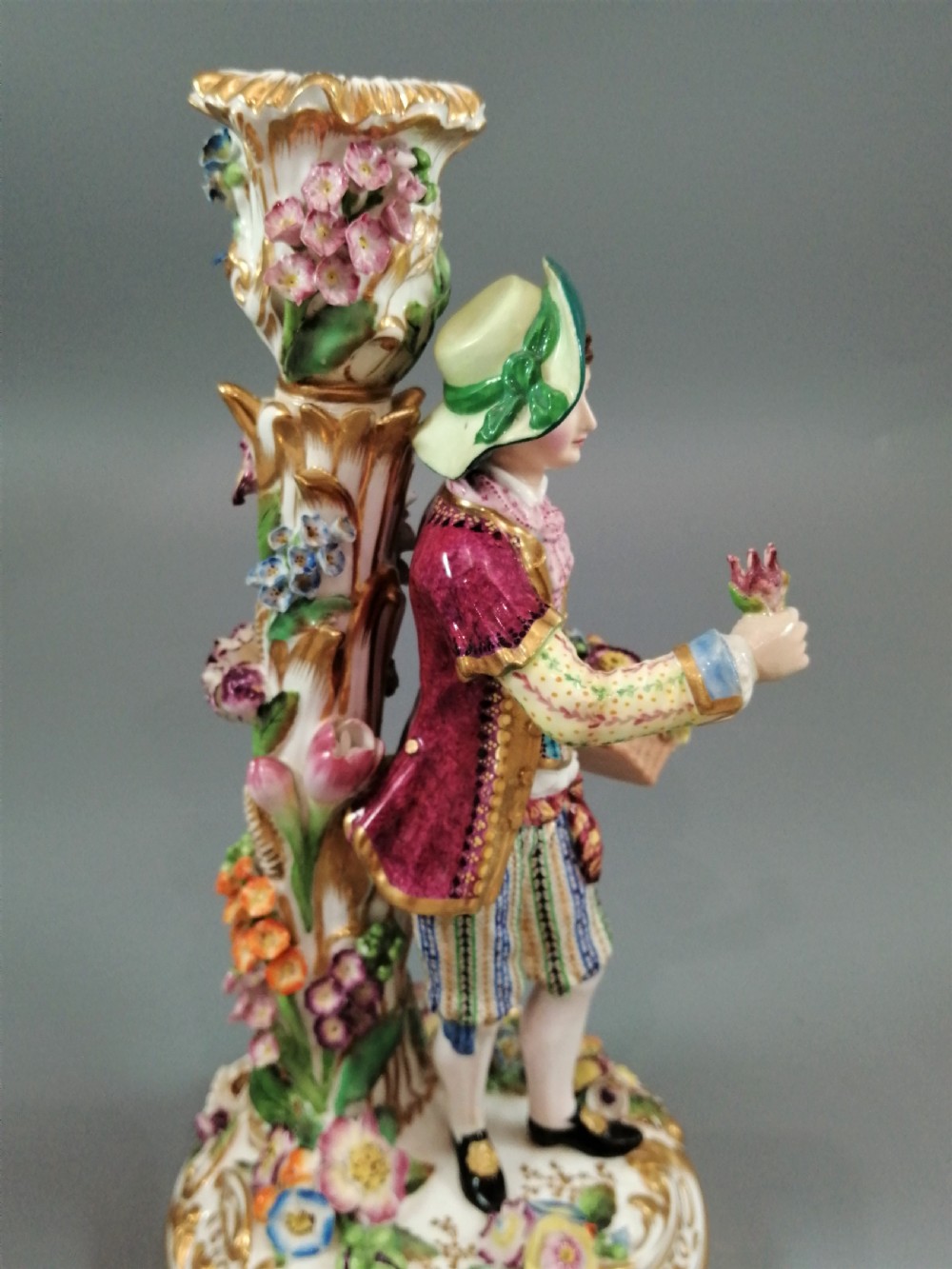 A pair of hand-painted Minton porcelain figural candlesticks featuring a male and female figure in colourful traditional dress with floral motifs and gilded scroll bases. View XXII