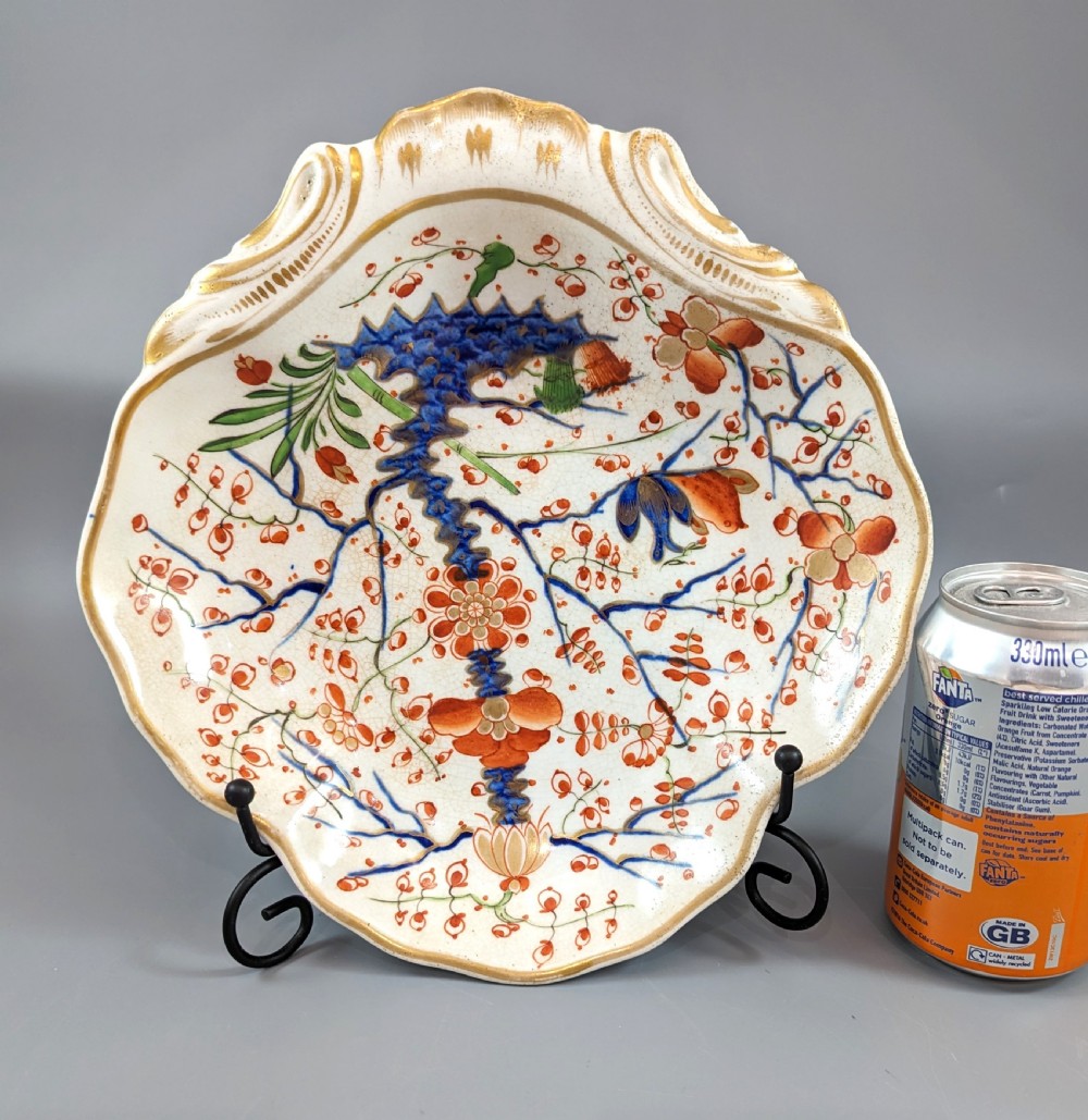 An antique shell-shaped porcelain plate featuring hand-painted Kakiemon-style motifs of two quails beneath flowering branches with gilt highlights. View X