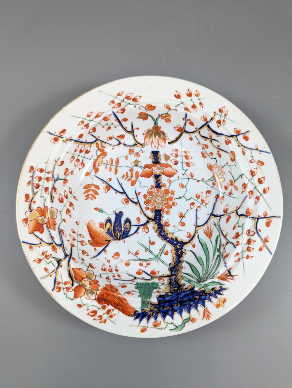 A circular antique porcelain butter dish with stand, decorated with hand-painted Japanese Kakiemon style quail and floral motifs in iron-red, blue, and gold. View VIII