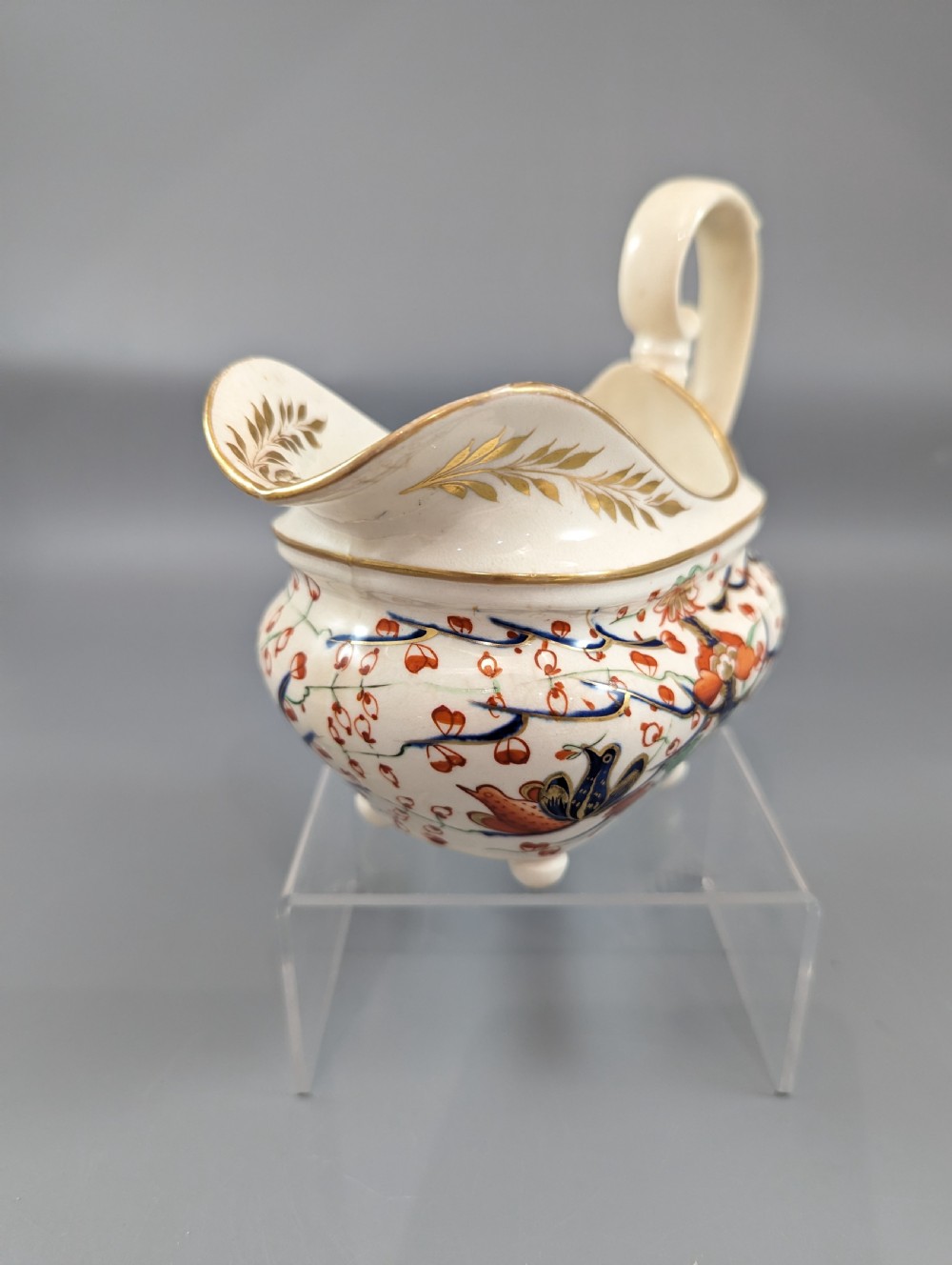 An antique cream-coloured porcelain jug featuring a hand-painted Two Quails design with gilded rim detailing and a raised loop handle. View VIII