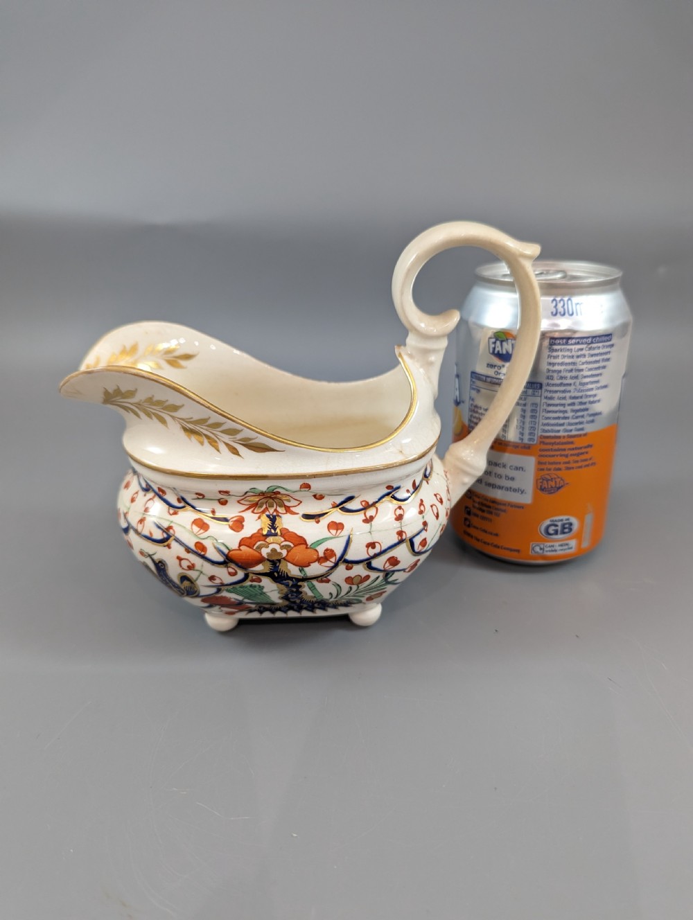 An antique cream-coloured porcelain jug featuring a hand-painted Two Quails design with gilded rim detailing and a raised loop handle. View XIV