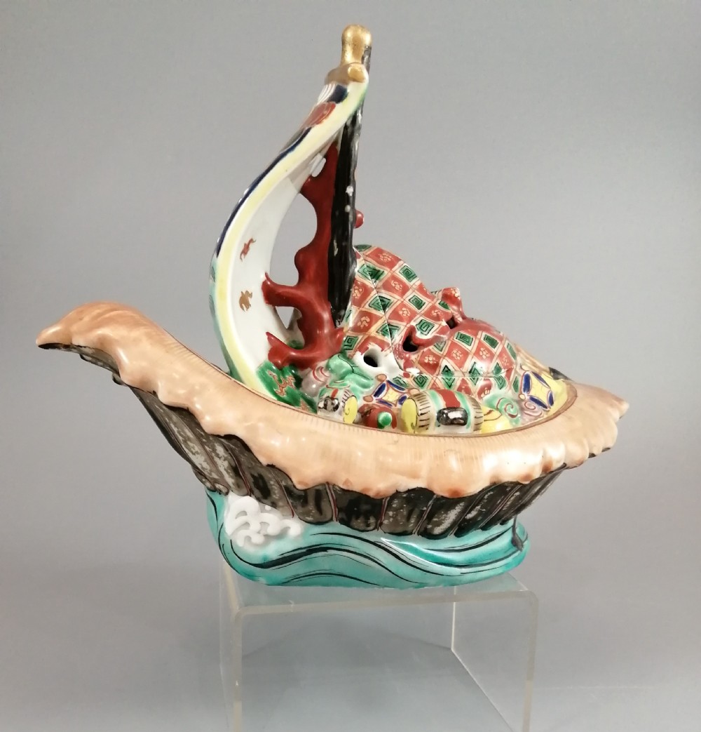 A Japanese Kutani porcelain censer shaped like a Takarabune treasure ship decorated with polychrome enamels and a wave-moulded base.