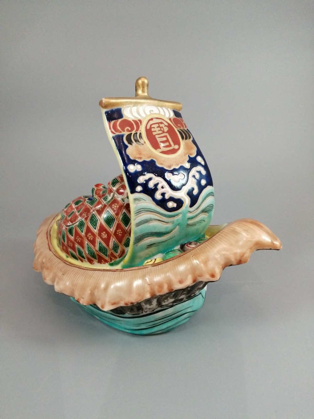 A Japanese Kutani porcelain censer shaped like a Takarabune treasure ship decorated with polychrome enamels and a wave-moulded base. View II