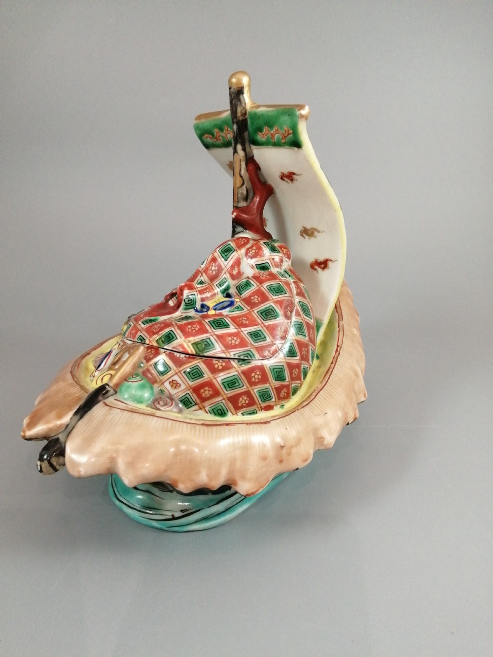 A Japanese Kutani porcelain censer shaped like a Takarabune treasure ship decorated with polychrome enamels and a wave-moulded base. View V