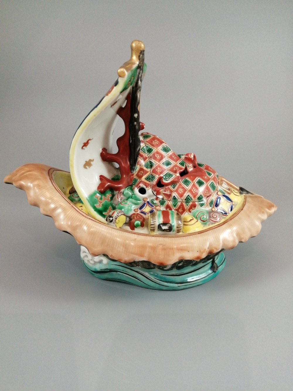 A Japanese Kutani porcelain censer shaped like a Takarabune treasure ship decorated with polychrome enamels and a wave-moulded base. View VIII