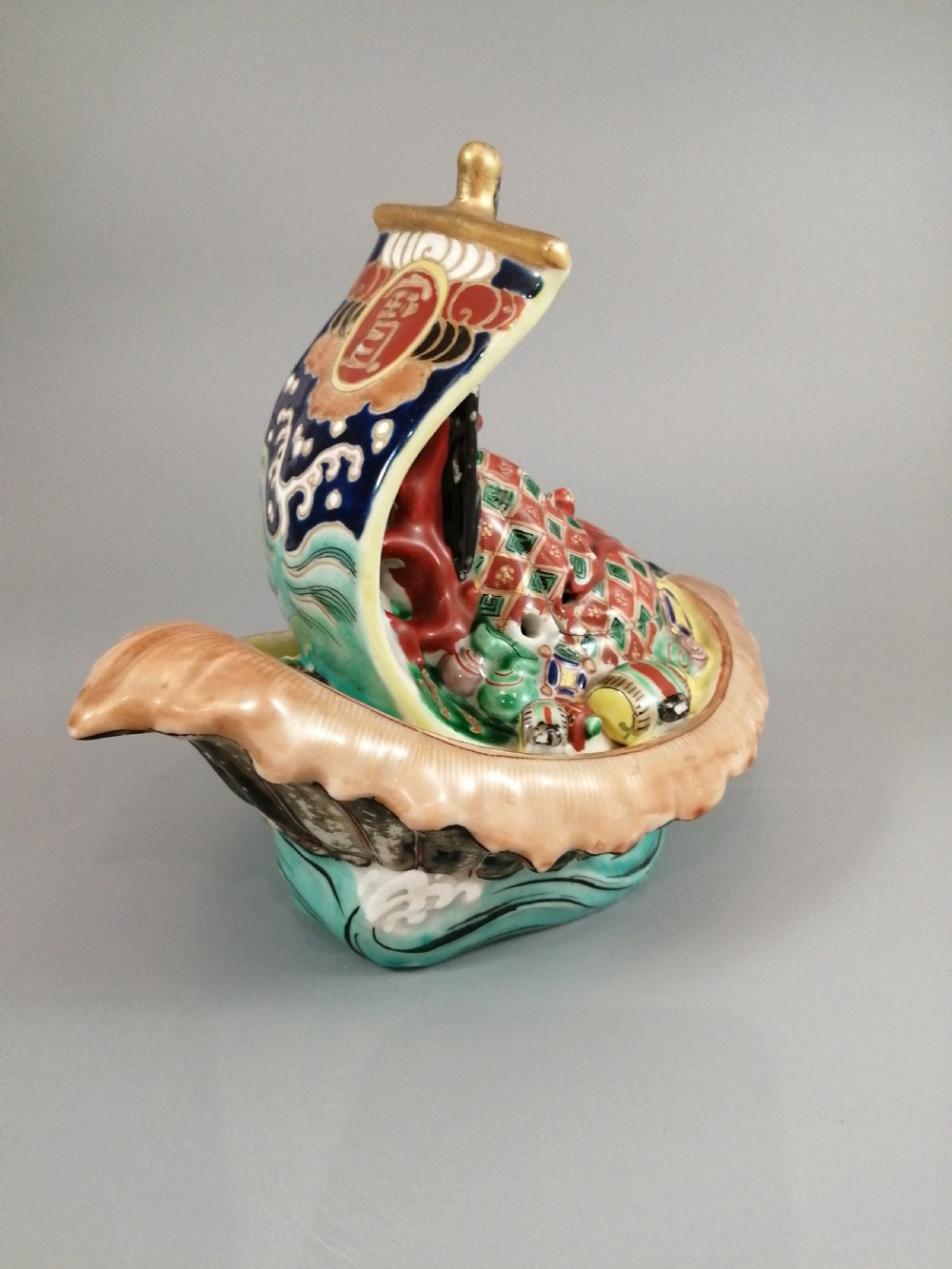 A Japanese Kutani porcelain censer shaped like a Takarabune treasure ship decorated with polychrome enamels and a wave-moulded base. View IX