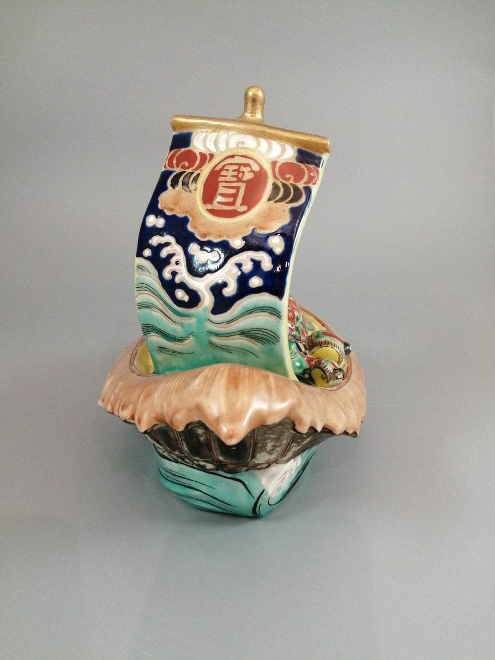 A Japanese Kutani porcelain censer shaped like a Takarabune treasure ship decorated with polychrome enamels and a wave-moulded base. View X