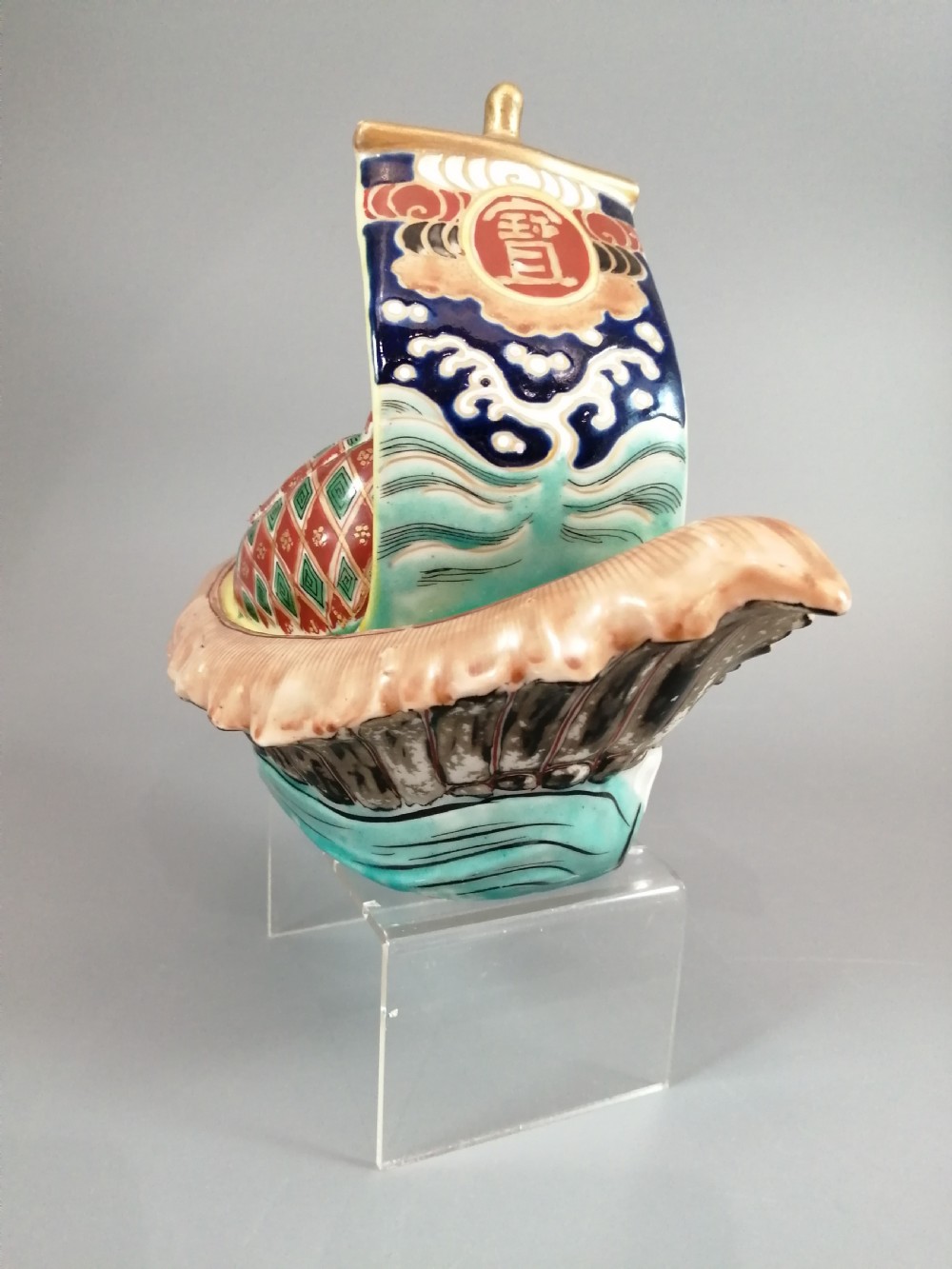 A Japanese Kutani porcelain censer shaped like a Takarabune treasure ship decorated with polychrome enamels and a wave-moulded base. View XIX