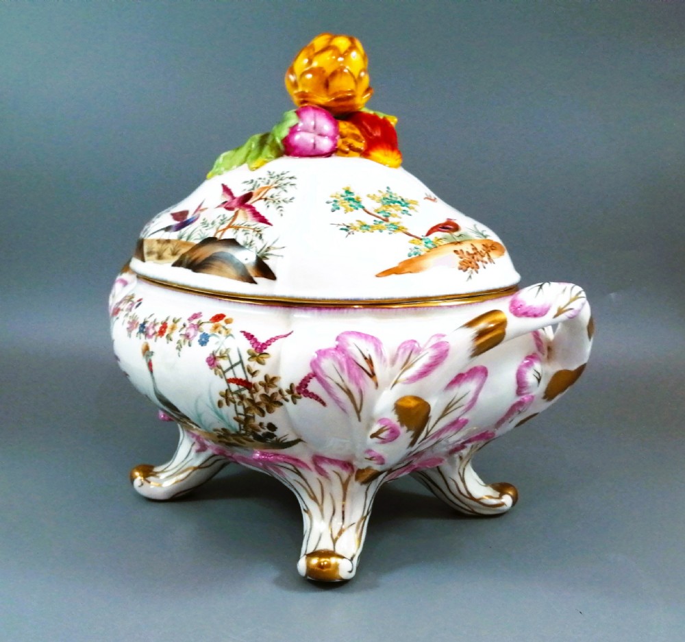 An antique continental porcelain soup tureen with a fruit finial lid, dual handles, and matching underplate, decorated with hand-painted birds and gilded scrollwork. View II