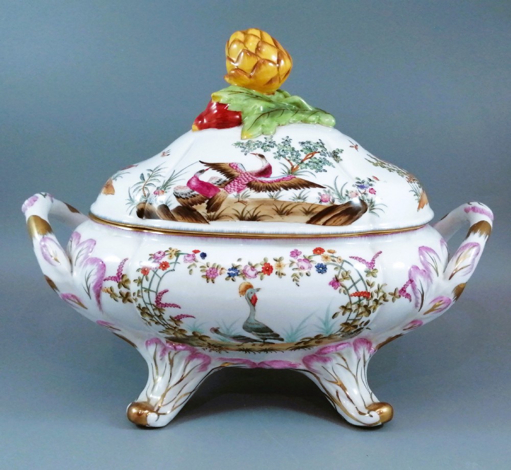 An antique continental porcelain soup tureen with a fruit finial lid, dual handles, and matching underplate, decorated with hand-painted birds and gilded scrollwork. View IV