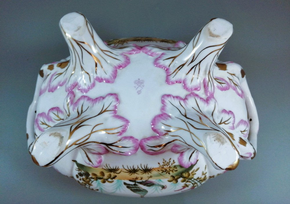 An antique continental porcelain soup tureen with a fruit finial lid, dual handles, and matching underplate, decorated with hand-painted birds and gilded scrollwork. View IX