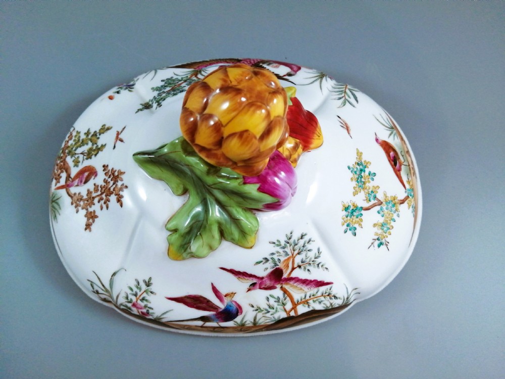An antique continental porcelain soup tureen with a fruit finial lid, dual handles, and matching underplate, decorated with hand-painted birds and gilded scrollwork. View XI